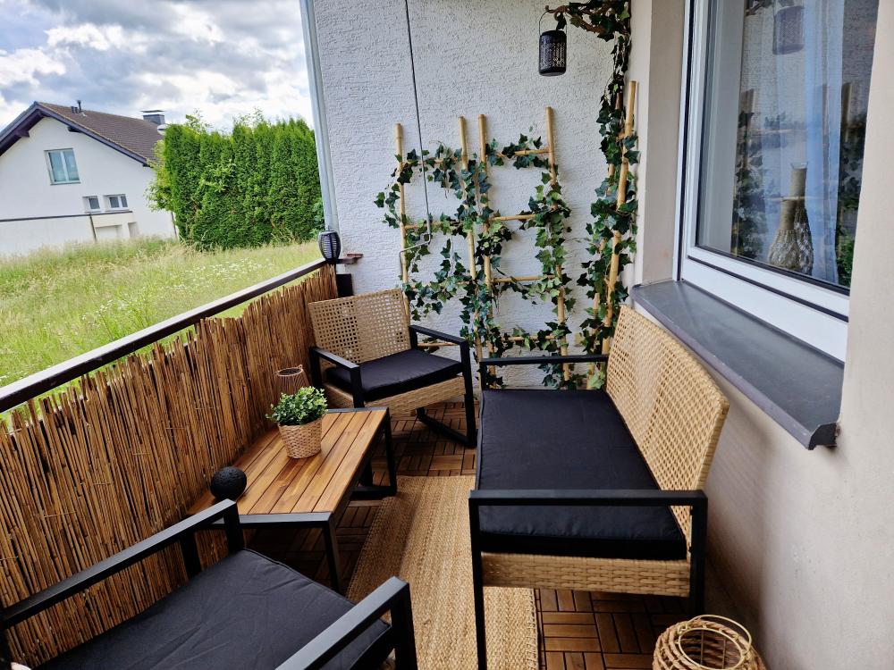 Balkon mit Tisch, Stühlen und Sonnenschirm an der Ferienwohnung in Winterberg.