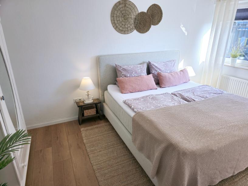 Ferienwohnung Möhnesee: Schlafzimmer mit Tageslicht, Bettwäsche und dekorativen Details.