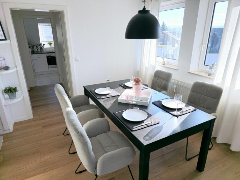 Essbereich der Ferienwohnung am Möhnesee mit Esstisch, vier Stühlen und Fensterblick.
