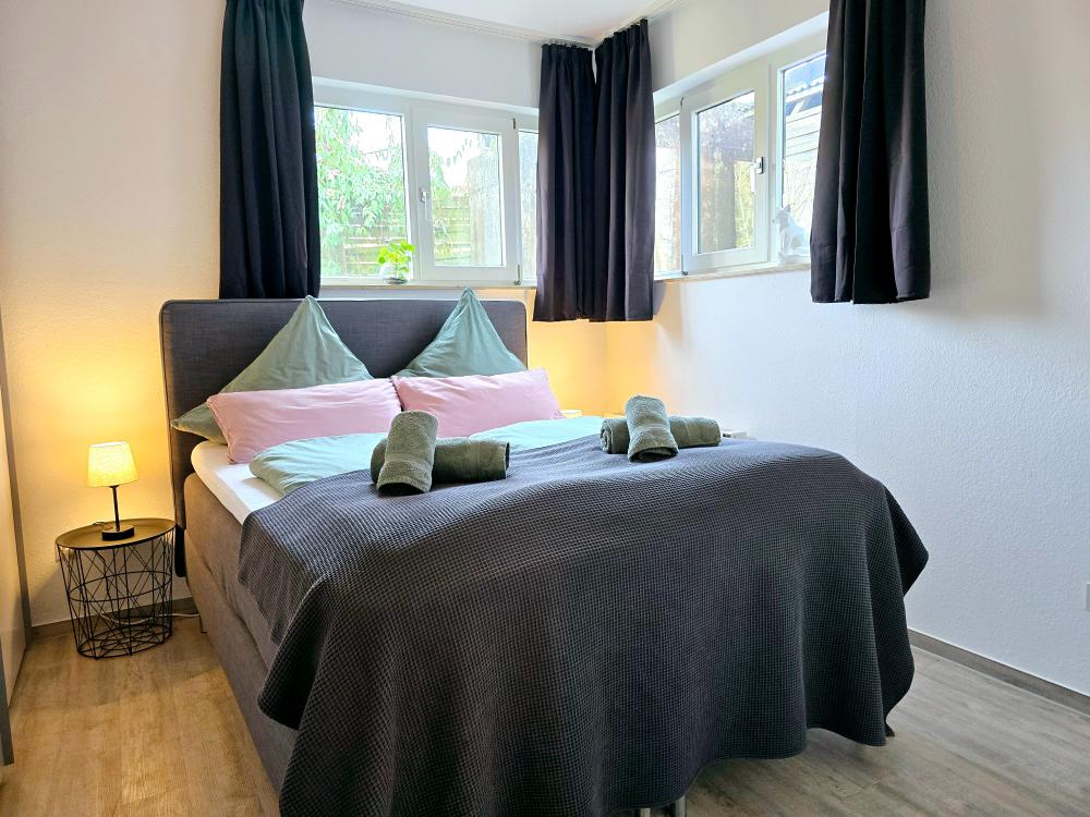 Ferienwohnung in Winterberg: Schlafzimmer mit Tageslicht, Bettwäsche und dekorativen Details.