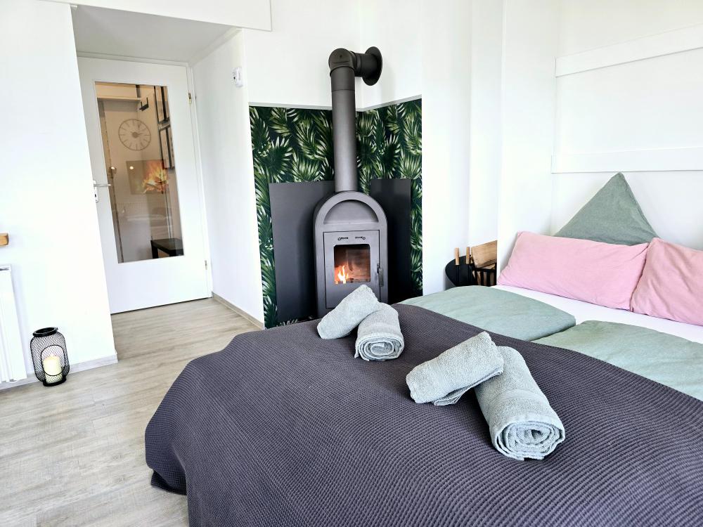 Schlafzimmer mit Doppelbett, Nachttischen und Fensterblick in der Ferienwohnung in Winterberg.