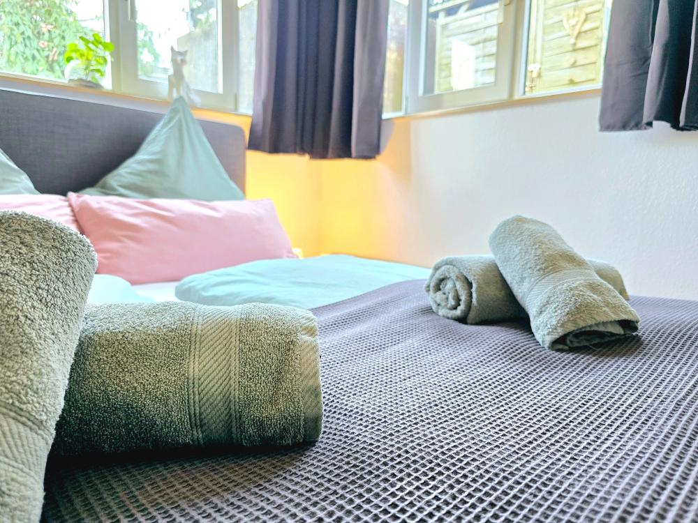 Schlafzimmer mit Dekokissen, Leselampe und ruhiger Atmosphäre.