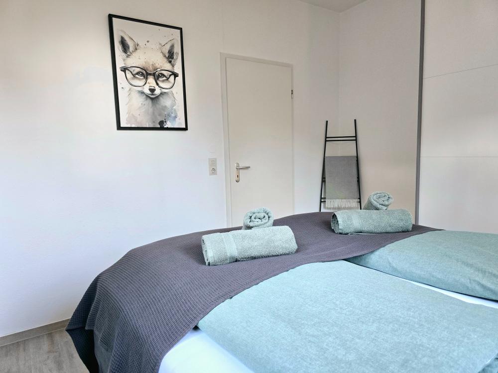 Schlafzimmer mit Handtüchern und ruhiger Atmosphäre.