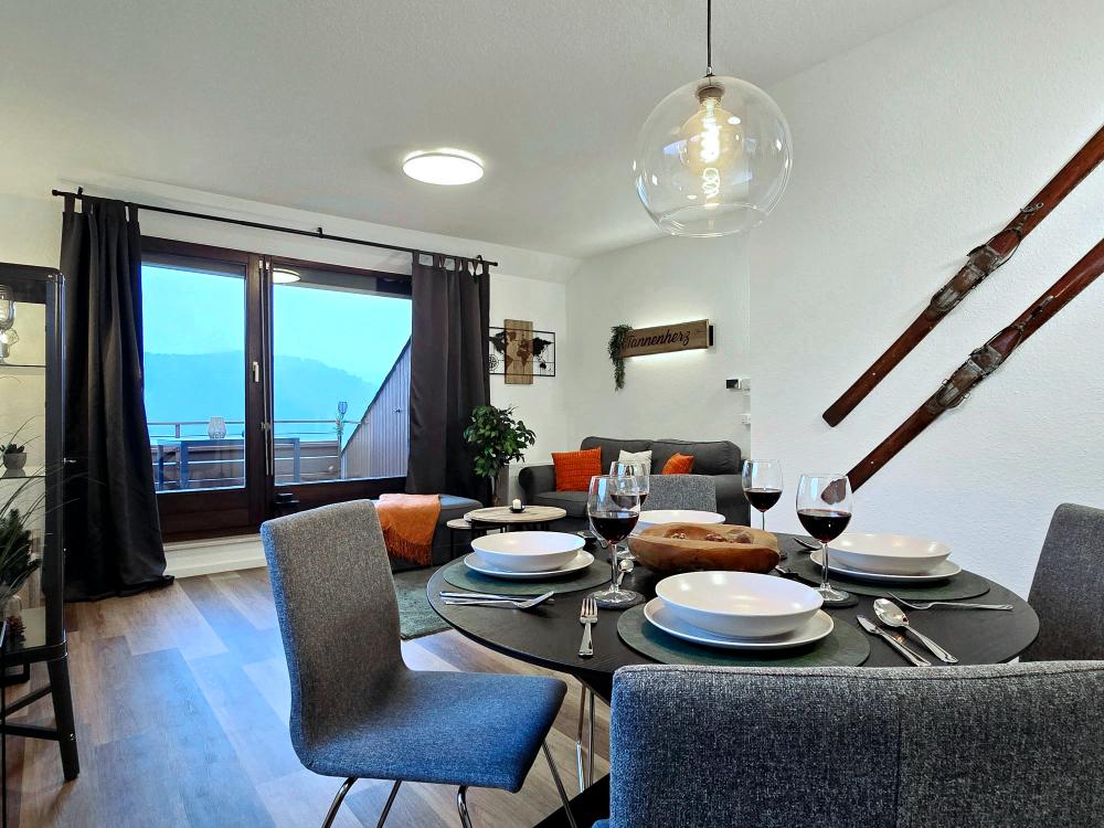 Essbereich der Ferienwohnung in Winterberg mit Esstisch, vier Stühlen und Fensterblick.