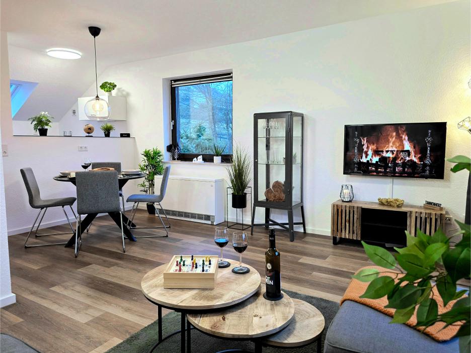 Ferienwohnung in Winterberg: Wohnzimmer mit Balkontür, Couchgarnitur und Couchtisch.