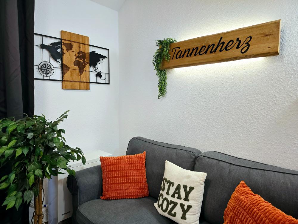 Sitzecke mit Sofa und Dekoration im Wohnzimmer der Ferienwohnung in Winterberg.