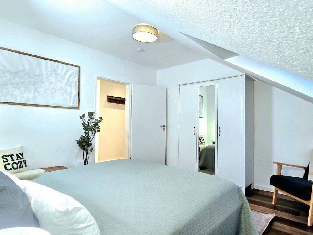 Schlafzimmer mit Dekokissen, Leselampe und ruhiger Atmosphäre.
