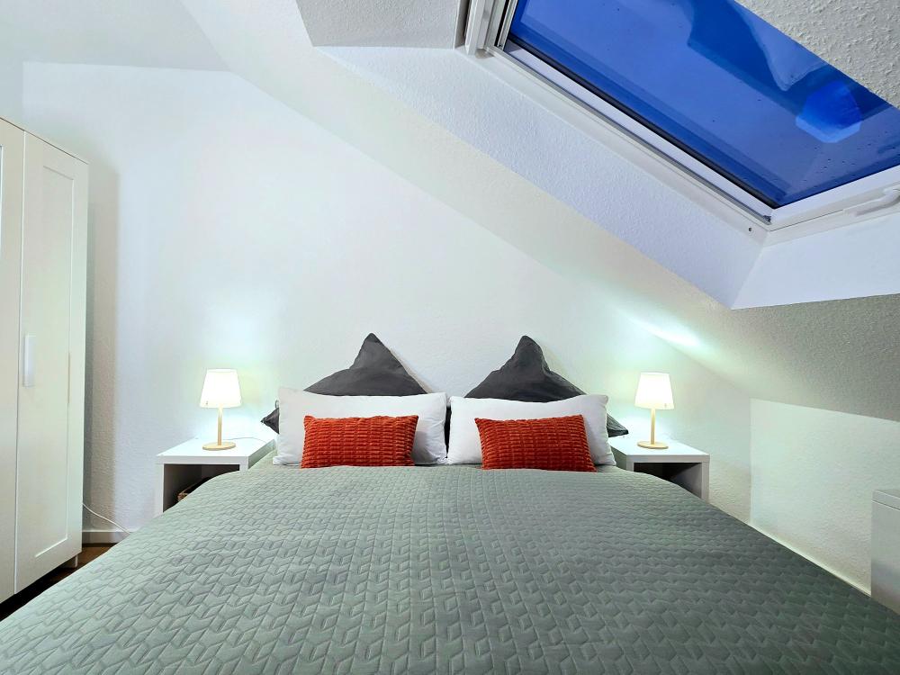 Ferienwohnung in Winterberg: Zweites Schlafzimmer mit Doppelbett und bunter Bettwäsche.