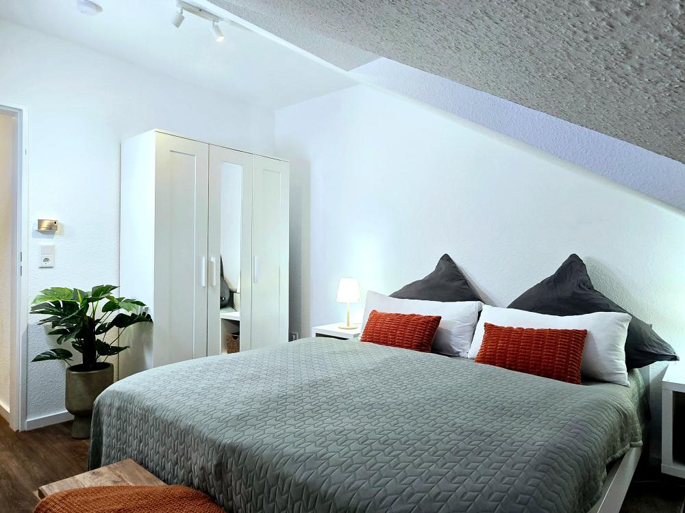 Schlafzimmer mit zwei Einzelbetten, Nachttischen und Fensterblick in der Ferienwohnung in Winterberg.