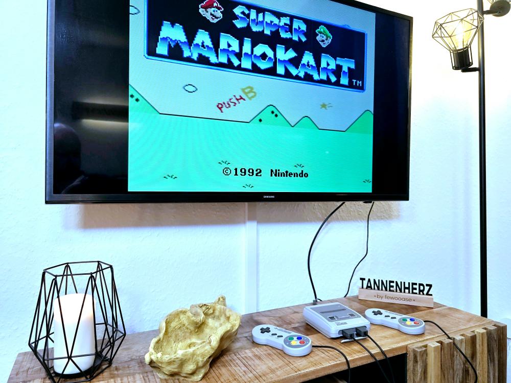 Spielekonsole Nintendo Mini SNES mit Controller und Mario Kart im Wohnzimmer der Ferienwohnung.