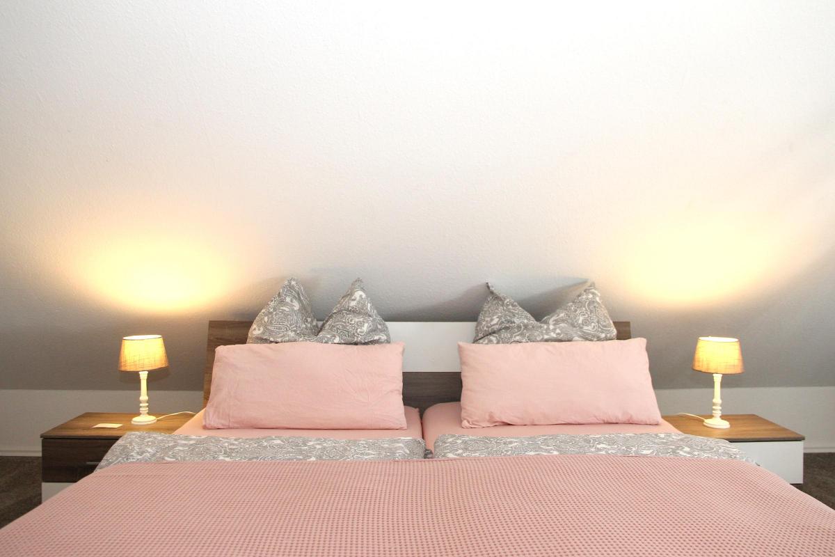 Ferienwohnung Möhnesee: Zweites Schlafzimmer mit Doppelbett und rosa Bettwäsche.