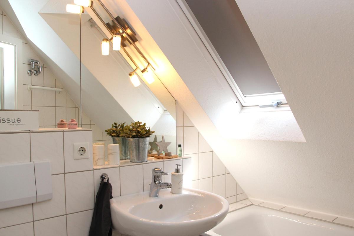 Zweites Badezimmer mit Spiegel, WC und Badewanne in der Ferienwohnung.