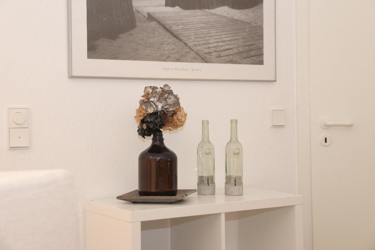 Dekobilder im Flur der Ferienwohnung mit Naturmotiven und Holzrahmen.